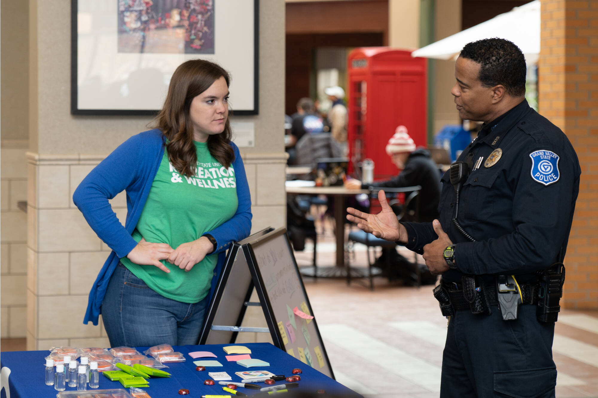 gv police officer talking cherrfully to another student on campus